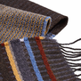 A detail shot of a patterned scarf with brown, blue and yellow stripes.